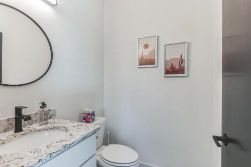 a white bathroom with a sink and a mirror at New Modern Townhome with Rooftop Patio townhouse in Iowa City
