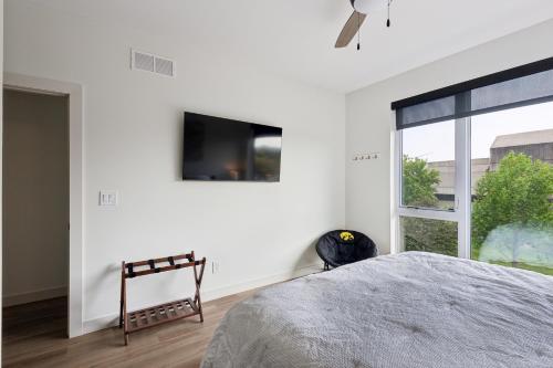 a bedroom with a bed and a large window at New Modern Townhome with Rooftop Patio townhouse in Iowa City