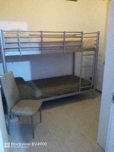 a room with a bunk bed and a chair at Villa incanto in Siculiana