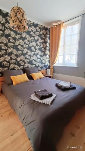 une chambre avec un grand lit avec des serviettes dessus dans l'établissement La nuit Fréventine, à Frévent