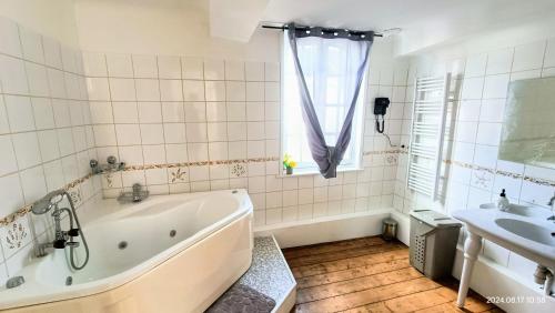 une salle de bain avec une baignoire et un lavabo dans l'établissement La nuit Fréventine, à Frévent