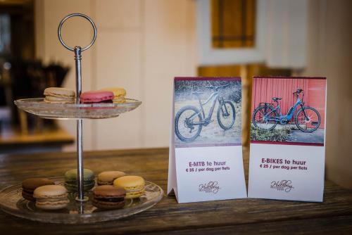 a table with two signs and a tray of donuts at B&B Hullebrug in Heist-op-den-Berg