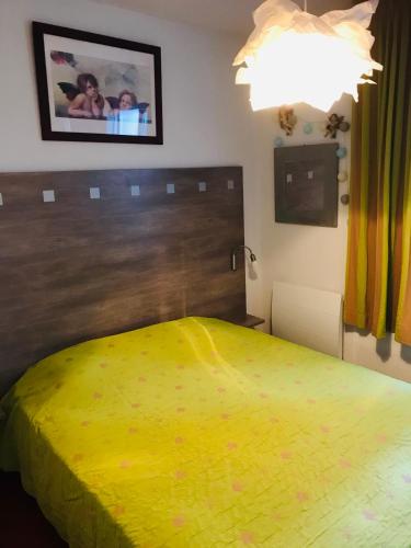 une chambre avec un lit avec un couvre-lit jaune dans l'établissement Gîte de standing climatisé, à Sainte-Cécile-les-Vignes