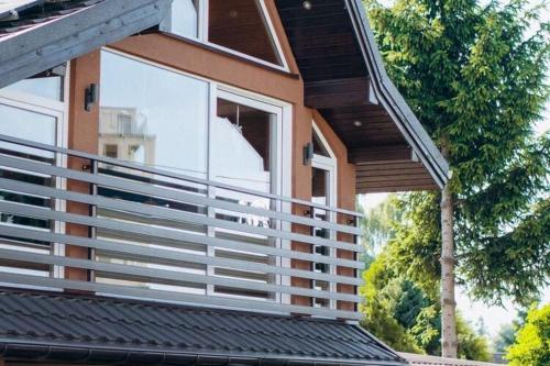a dog sitting on a balcony of a house at Holiday Home Ko czewo near Lakes and Forests in Kołczewo