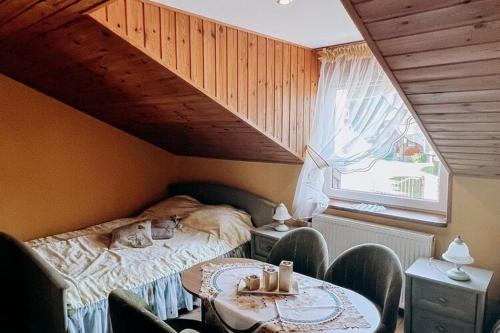 a bedroom with a bed and a table and chairs at Holiday Home Ko czewo near Lakes and Forests in Kołczewo