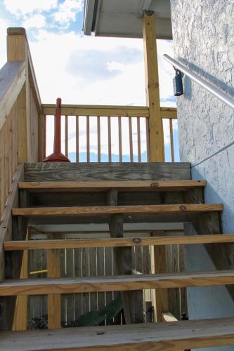 a set of wooden stairs leading up to a balcony at Pool with Canal views Minutes 2 beach BBQ Pit in Padre Island