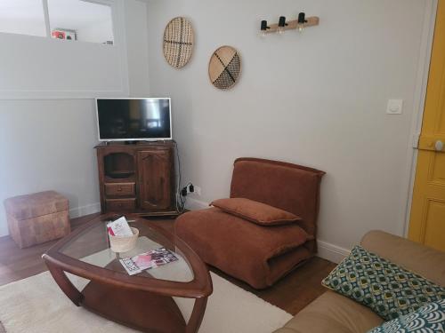 a living room with a coffee table and a chair at Le Duplex in Vatan