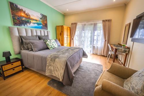 a bedroom with a bed and a chair and a couch at Botanica Guest House in George