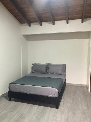a bedroom with a bed in a white room at Apartahotel Poblado-Aguacatala in Envigado