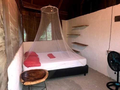 a room with a bed with a wooden bowl on it at HOSTAL MIRADOR dentro del parque tayrona in El Zaino