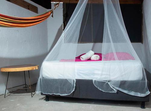 a bed with a mosquito net on top of it at HOSTAL MIRADOR dentro del parque tayrona in El Zaino