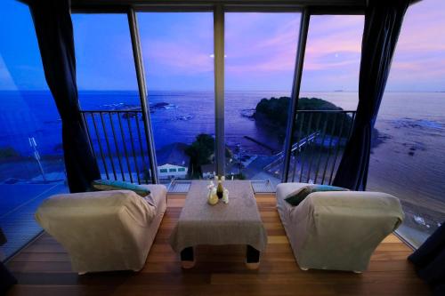 a living room with a view of the ocean at Ocean View Hiromi SPA Hotel温泉と絶景の宿 in Shimoda