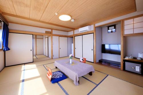 a living room with a table and a tv at Ocean View Hiromi SPA Hotel温泉と絶景の宿 in Shimoda