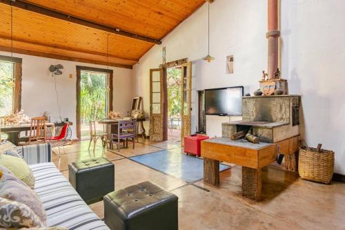 a living room with a couch and a tv at Casa Quereres - autenticidade e afeto in Brumadinho