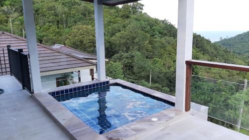 a swimming pool on the balcony of a house at Than Prawet Waterfall villa in Thong Nai Pan Noi