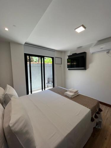 a bedroom with a large white bed and a window at Pousada do Canto in Abraão