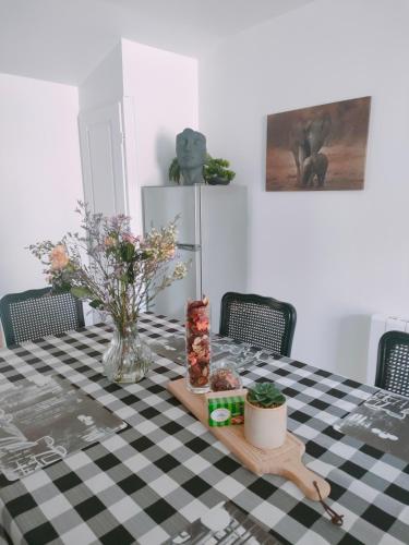 a table with a black and white checkered table cloth at Maison le Merzer, entre terre et mer in Le Merzer