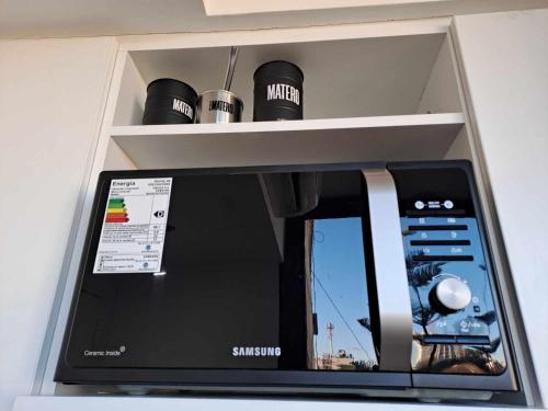 a samsung microwave in a kitchen with a shelf at Relax en Colegiales in Buenos Aires