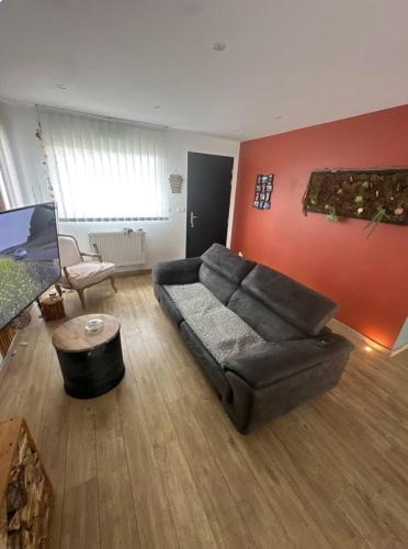 un salon avec un canapé et une table dans l'établissement Chambre dans une maison chaleureuse, à Fouquières-lès-Béthune