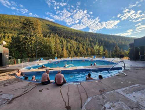 un grupo de personas sentadas en una piscina en Michaud's Basement unit, en Nakusp