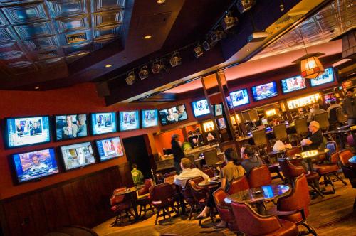a group of people sitting at a bar with televisions at Carson Valley Inn in Minden