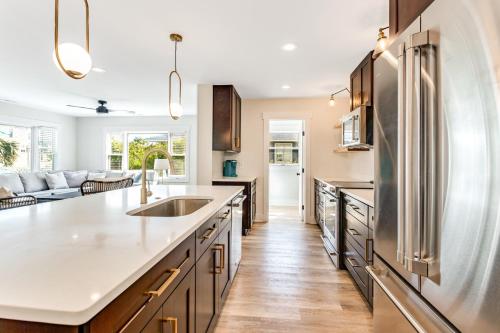 a kitchen with a stainless steel refrigerator and wooden cabinets at Family Tides by Sea Scape Properties in Wrightsville Beach