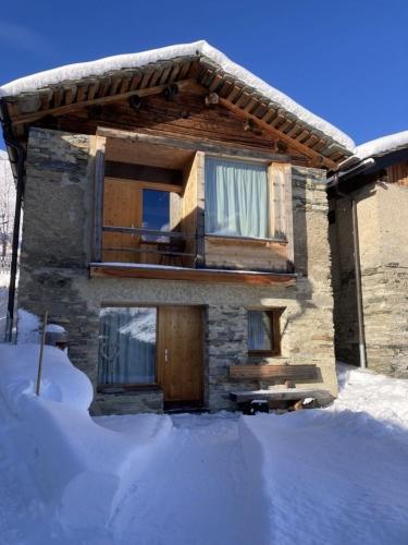 a house with snow in front of it at Gääschi Leis in Vals
