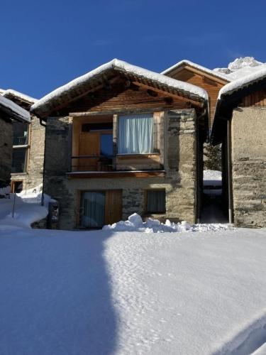 a house with snow on the ground in front of it at Gääschi Leis in Vals