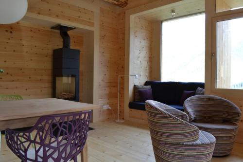 a living room with wooden walls and a wooden table and chairs at Gääschi Leis in Vals