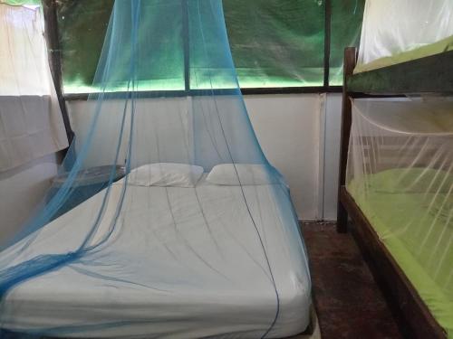 a small bed in a room with a window at HOSTAL MIRADOR dentro del parque tayrona in El Zaino