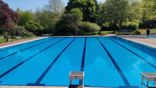 a large swimming pool with blue water at Sterne Luxus Heidesonne in Jesteburg
