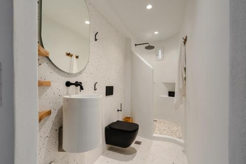 Un baño blanco con lavabo y espejo. en Diamond of Cyclades, en Naxos Chora