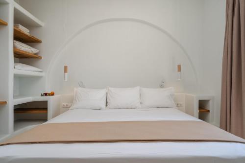 1 cama blanca con almohadas blancas en una habitación en Diamond of Cyclades, en Naxos Chora