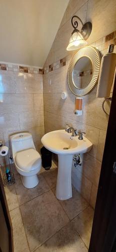 a bathroom with a sink and a toilet and a mirror at Boca Chica Bay Eco Lodge in Boca Chica