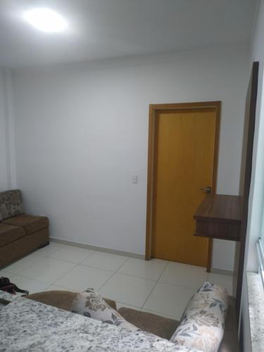 sala de estar con cama y puerta de madera en Apartamento centro, en Ubá