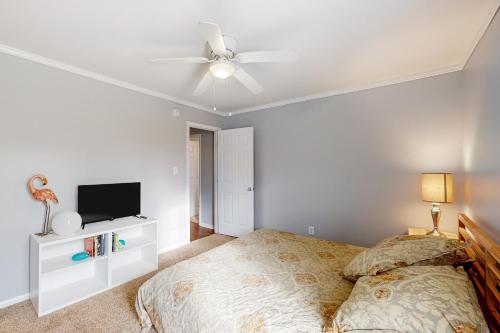 a bedroom with a bed and a ceiling fan at Swansboro Serenity in Swansboro