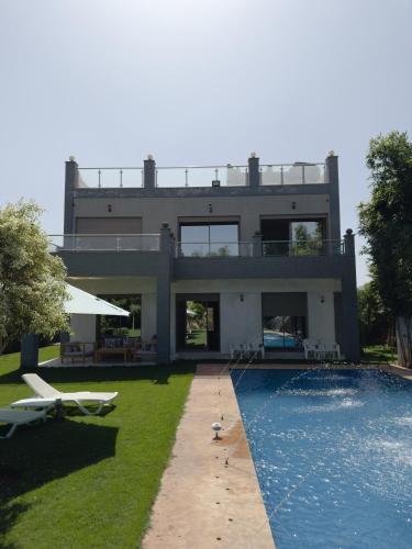 a house with a swimming pool in front of it at Villa luxueuse Marrakech Ourika in Ourika