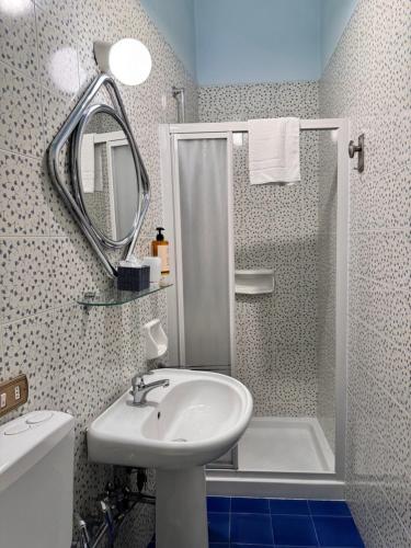 a bathroom with a sink and a shower with a mirror at Le Muse in Pisa