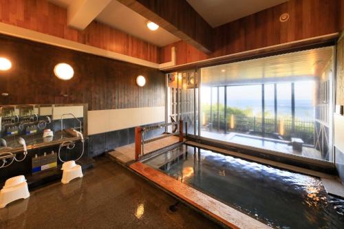 a large bathroom with a hot tub in it at Ocean View Hiromi SPA Hotel温泉と絶景の宿 in Shimoda