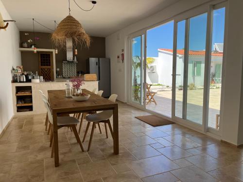 una cucina e una sala da pranzo con tavolo e sedie di B&B Casa Areia a Colares
