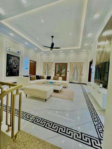 a living room with white furniture and a ceiling at Emerald Villa Swat in Ghurejo