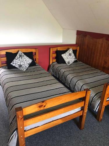 two beds sitting next to each other in a room at Charming Spacious Rural Otaki Retreat in Otaki