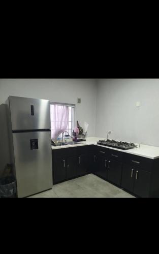 a kitchen with a stainless steel refrigerator and a window at Habitación en Monterrey Centro in Monterrey
