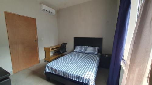 a small bedroom with a bed and a desk at Habitación en Monterrey Centro in Monterrey