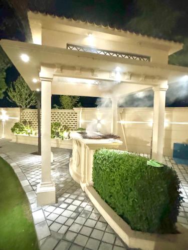 a white gazebo with a hedge in front of it at Emerald Villa Swat in Ghurejo