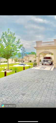 a car parked in front of a house with a driveway at Emerald Villa Swat in Ghurejo