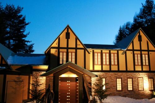 a large house with a brown door in the snow at Dormy Club Karuizawa in Karuizawa