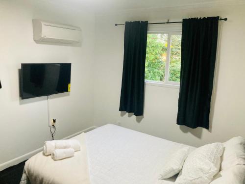 a bedroom with a bed and a tv and a window at 1940s Urban charmer modern upgrades in Auburn