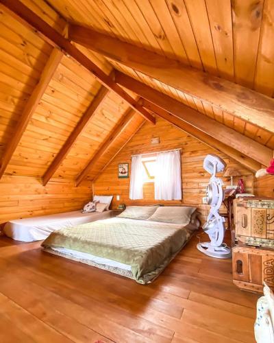 a bedroom with a bed in a wooden cabin at Refúgio da Montanha Brasil in Alfredo Wagner