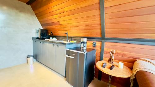 a kitchen with a sink and a table in a room at Chalé Das Flores in Teresópolis